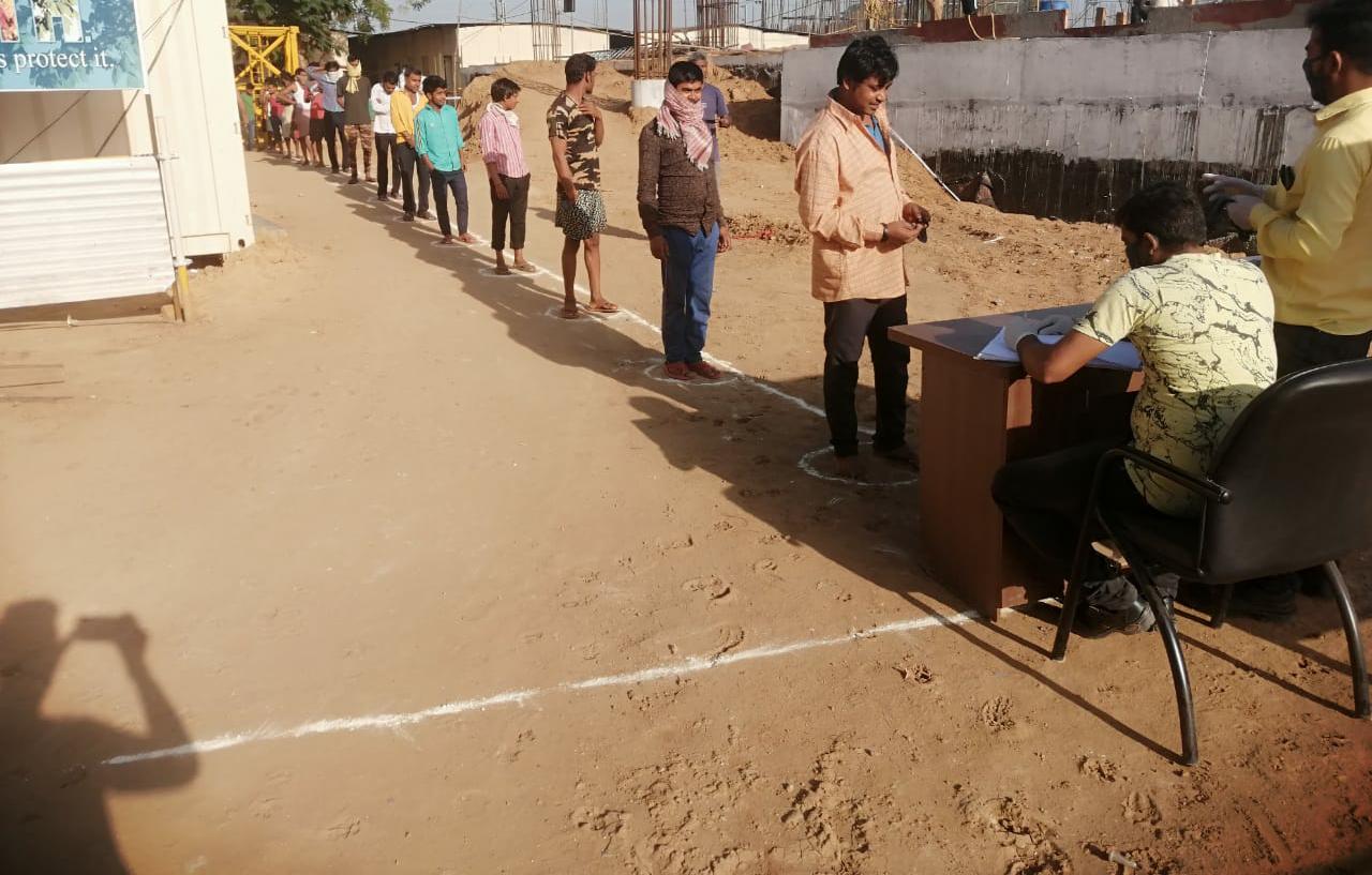 साबरमती पैसेंजर हब निर्माण स्थल पर निर्माण श्रमिकों को मास्क और सैनिटाइजेशन सामग्री वितरित की जा रही है।